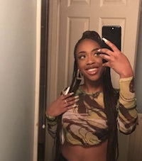 a young woman taking a selfie in a camouflage top
