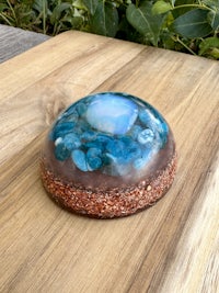 a blue opal stone sitting on top of a wooden table