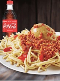 a plate of spaghetti and a bottle of coca cola