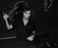 a man in a black shirt is djing in a dark room