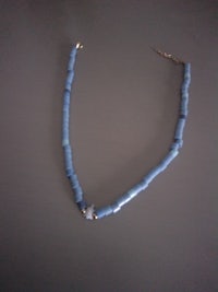 a blue beaded necklace with a gold clasp