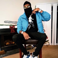 a man in a blue jacket sitting on a chair