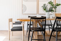 a dining room with a wooden table and black chairs