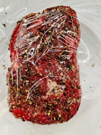 a piece of meat wrapped in plastic on a plate