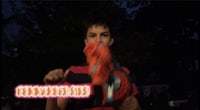 a boy holding an orange toy in his hand