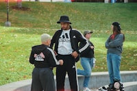 a man in a hat talking to a woman on a skateboard