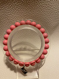 a pink bead bracelet on a white surface
