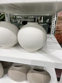 white vases on a shelf in a store