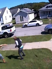 a man and a woman are fighting in a backyard