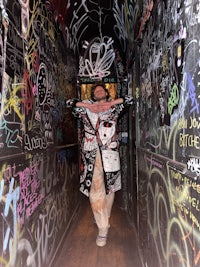 a person standing in a room covered in graffiti