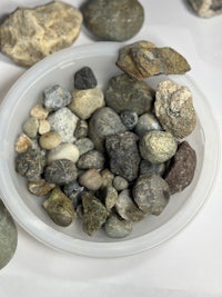 rocks in a bowl on a white surface