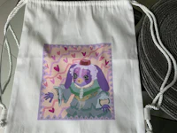 a white drawstring bag with an image of a bunny