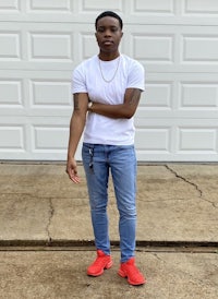 a young man wearing a white t - shirt and blue jeans