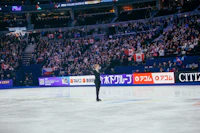 a figure skater is performing in front of an audience