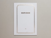 a white book with gold foil on it that says death book