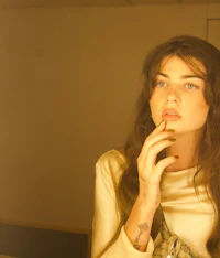 a woman in a gold dress smoking a cigarette