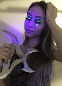 a woman holding a glow in the dark knife