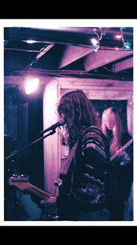 a group of people playing a guitar in a dark room