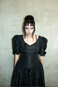 a woman in a black dress posing for a picture