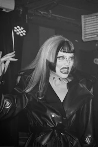 a black and white photo of a woman in a leather jacket