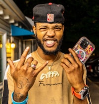 a man with tattoos holding a cell phone
