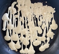 pancakes in a frying pan with melted butter