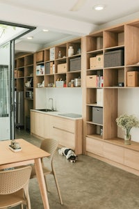a kitchen with wooden shelves and a dog on the floor