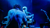 a man sitting on a keyboard at a concert
