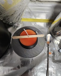 a candle on a plate with a spoon on it