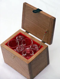 a wooden box with four glasses in it