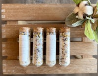 four bottles of bath salts on a wooden crate