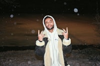 a man in a white jacket with a peace sign in the snow