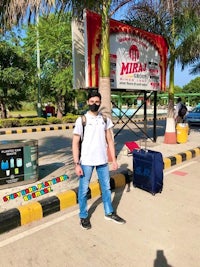 a man in a mask standing in front of a sign