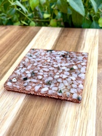 a small stone coaster sitting on top of a wooden table