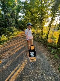 a person standing on a skateboard in a wooded area