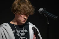 a young man is standing in front of a microphone