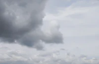 a person is flying a kite in a cloudy sky