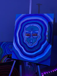 a blue and purple painting on a table in a dark room