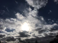 the sun shines through a cloudy sky