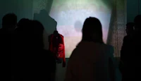 a group of people standing in front of a projection