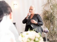 a woman speaking into a microphone at a wedding