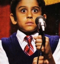 a young boy in a vest and tie is holding a microphone