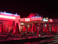a diner with tables and umbrellas at night