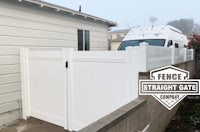 a white rv parked next to a white fence