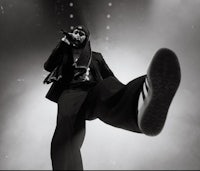 a black and white photo of a man standing on a stage