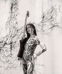 a black and white photo of a woman holding a guitar