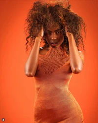 a woman in an orange dress posing for a photo