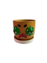 a yellow flower pot with green eyes on it