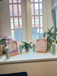 a window sill with candles and plants on it