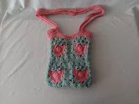 a crocheted bag with pink and blue hearts on it